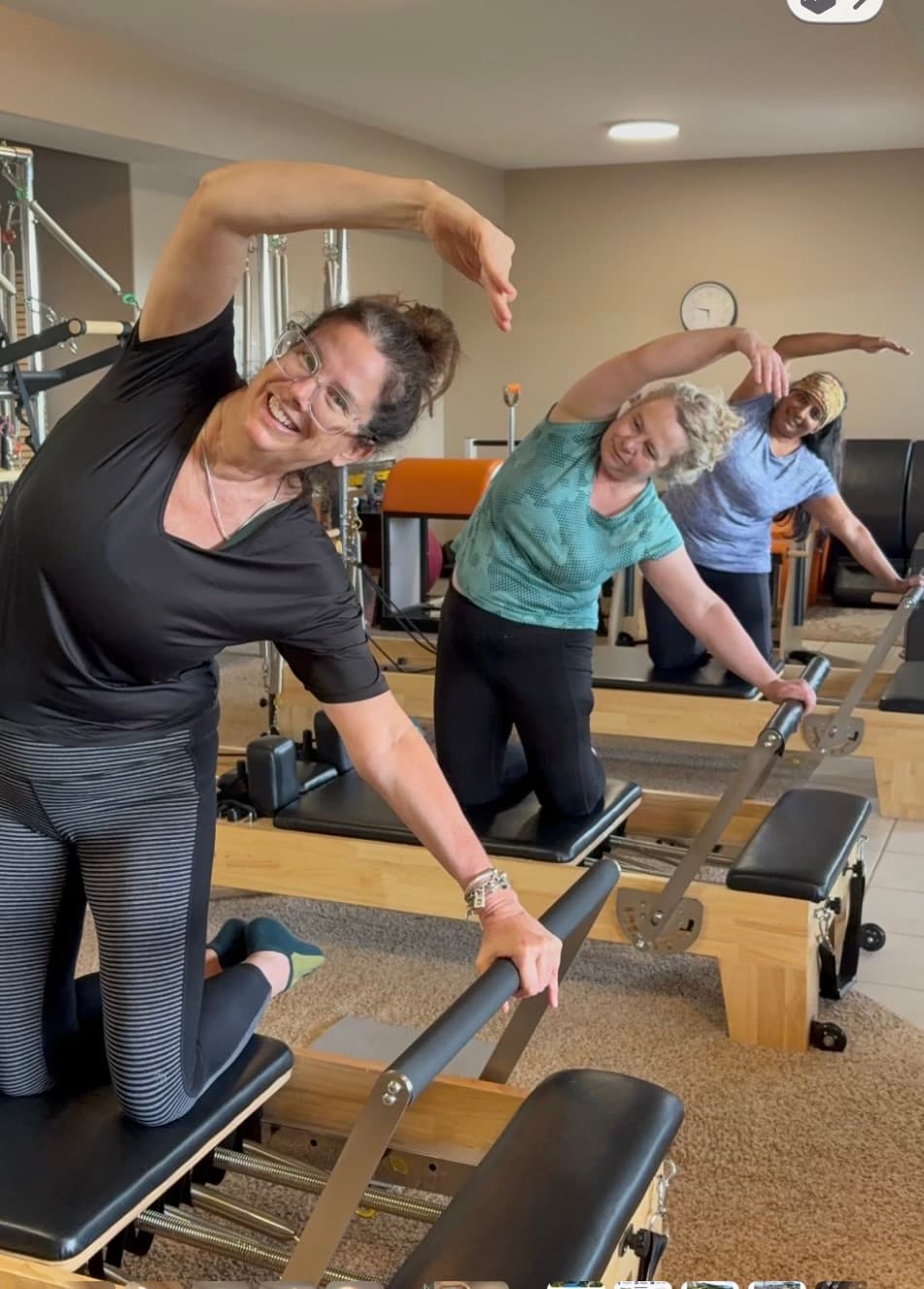 Students of different ages practicing Pilates together