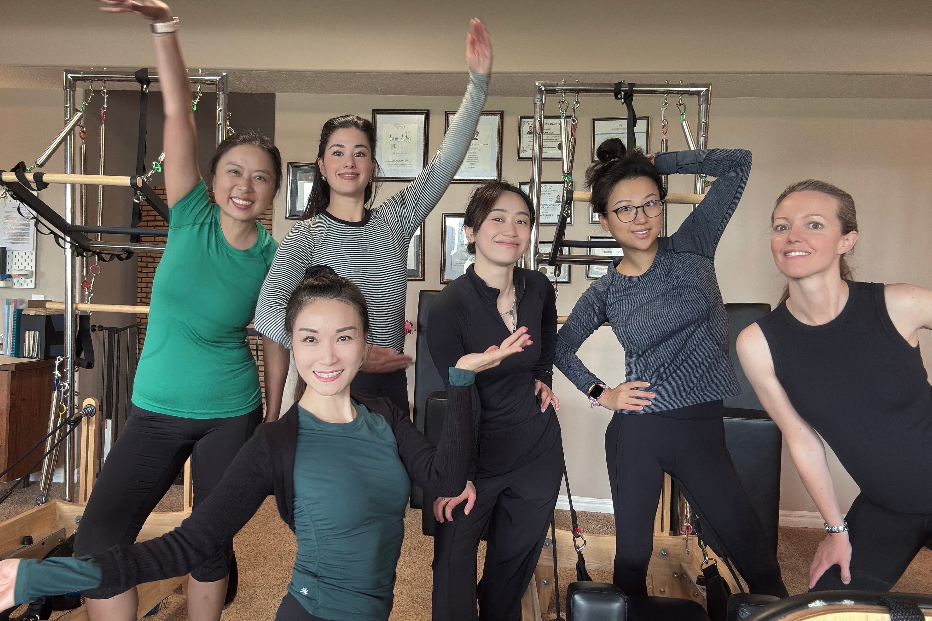Pilates studio members stretching together during a session